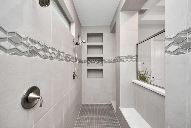 12813 N Palomino Lake Cir, Cypress, TX 77429 - bathroom featuring a tile shower, tile patterned flooring, and tile walls