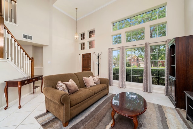 9715 Therrell Dr, Houston, TX 77064 - living area featuring light tile patterned flooring, crown molding, a towering ceiling, stairs, and baseboards