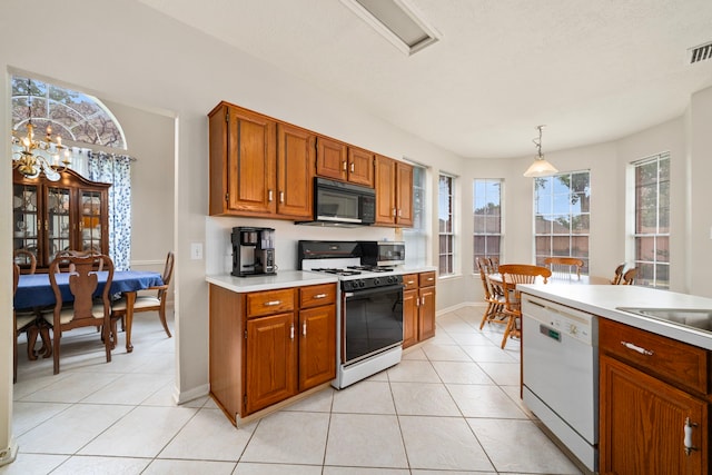 9715 Therrell Dr, Houston, TX 77064 - kitchen with white appliances, light countertops, light tile patterned floors, and brown cabinetry