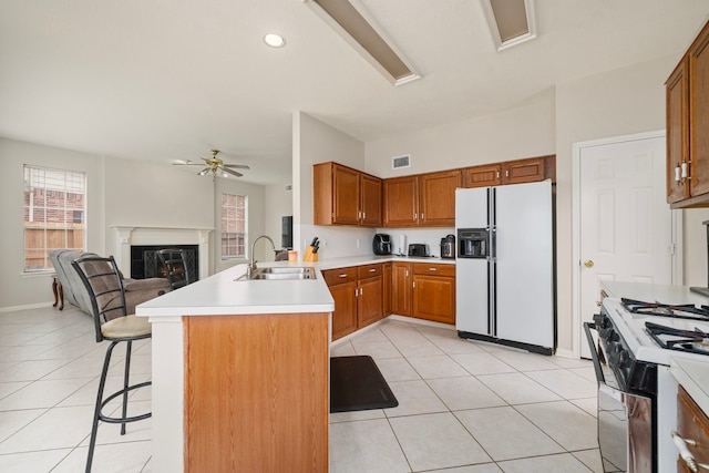 9715 Therrell Dr, Houston, TX 77064 - kitchen featuring white appliances, a sink, a peninsula, ceiling fan, and a kitchen bar
