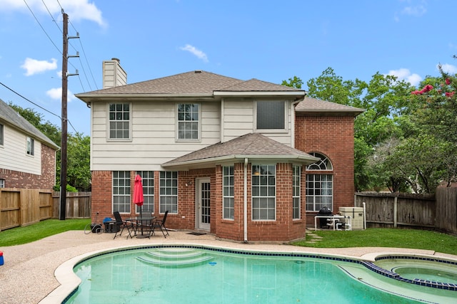 9715 Therrell Dr, Houston, TX 77064 - back of property featuring a fenced backyard, brick siding, a chimney, and a patio area