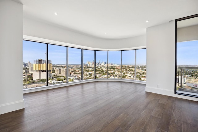 1701 Hermann Dr Unit 27Ce, Houston, TX 77004 - spare room with a view of city, dark wood finished floors, healthy amount of natural light, baseboards, and recessed lighting