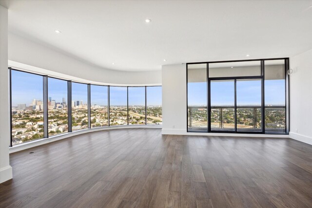 1701 Hermann Dr Unit 27Ce, Houston, TX 77004 - unfurnished living room with dark wood-style flooring, baseboards, a view of city, and recessed lighting
