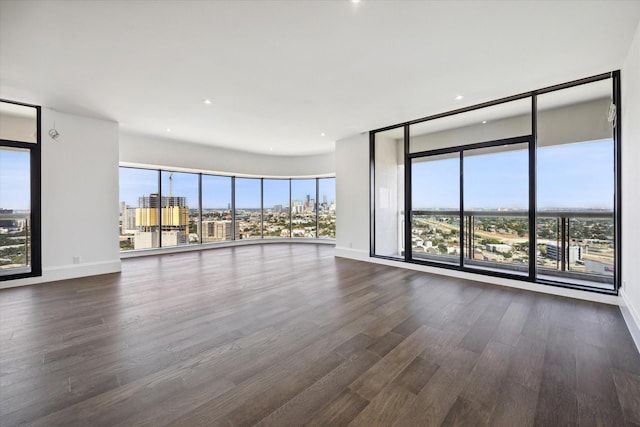 1701 Hermann Dr Unit 27Ce, Houston, TX 77004 - unfurnished living room with a view of city, dark wood-style floors, plenty of natural light, and baseboards