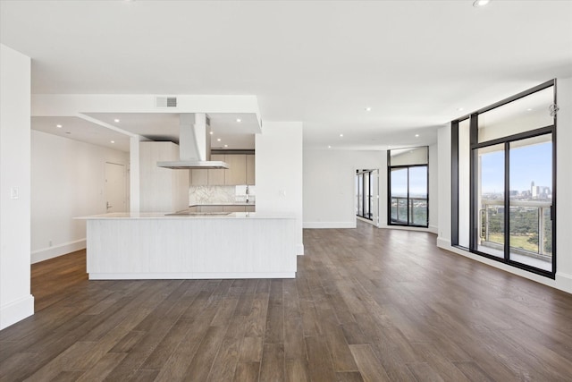 1701 Hermann Dr Unit 27Ce, Houston, TX 77004 - kitchen with wall chimney range hood, modern cabinets, dark wood finished floors, baseboards, and light countertops