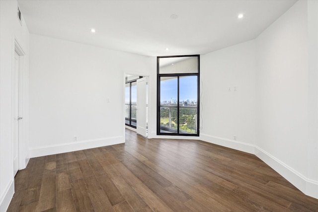 1701 Hermann Dr Unit 27Ce, Houston, TX 77004 - empty room featuring dark wood-type flooring, baseboards, and recessed lighting