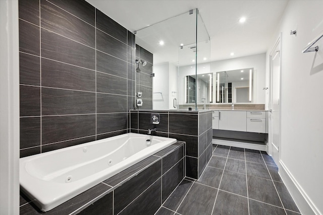 1701 Hermann Dr Unit 27Ce, Houston, TX 77004 - bathroom featuring a jetted tub, vanity, tile patterned flooring, tiled shower, and baseboards