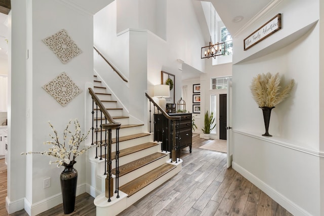 38 Agate Stream Pl, The Woodlands, TX 77381 - foyer featuring wood finished floors, stairway, baseboards, a towering ceiling, and a chandelier