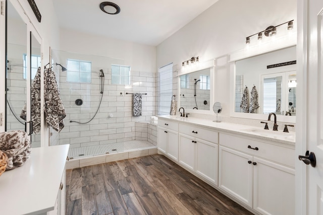 38 Agate Stream Pl, The Woodlands, TX 77381 - full bathroom with double vanity, tiled shower, and wood finished floors