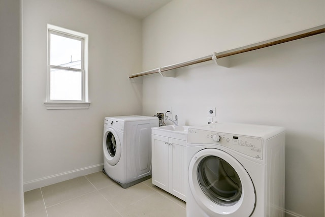 9622 Fannin Sta W, Houston, TX 77045 - laundry room with cabinet space, washing machine and dryer, baseboards, and light tile patterned floors
