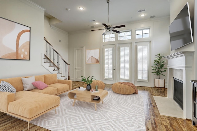 9622 Fannin Sta W, Houston, TX 77045 - living area featuring wood finished floors, a ceiling fan, a premium fireplace, crown molding, and stairway