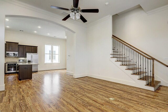 9622 Fannin Sta W, Houston, TX 77045 - unfurnished living room featuring arched walkways, a ceiling fan, crown molding, light wood-style flooring, and stairway