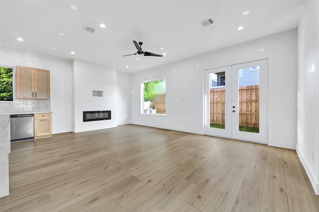 5107 New Orleans St, Houston, TX 77020 - unfurnished living room featuring healthy amount of natural light, ceiling fan, recessed lighting, light wood finished floors, and a glass covered fireplace
