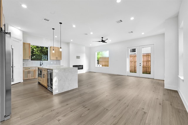 5107 New Orleans St, Houston, TX 77020 - kitchen with appliances with stainless steel finishes, wine cooler, a ceiling fan, light wood finished floors, and recessed lighting