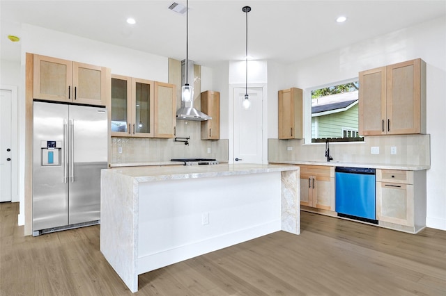5107 New Orleans St, Houston, TX 77020 - kitchen with built in refrigerator, dishwasher, wall chimney range hood, light wood-type flooring, and light countertops