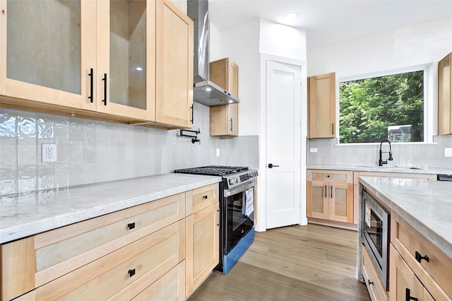 5107 New Orleans St, Houston, TX 77020 - kitchen with light brown cabinets, appliances with stainless steel finishes, wall chimney range hood, a sink, and light stone countertops