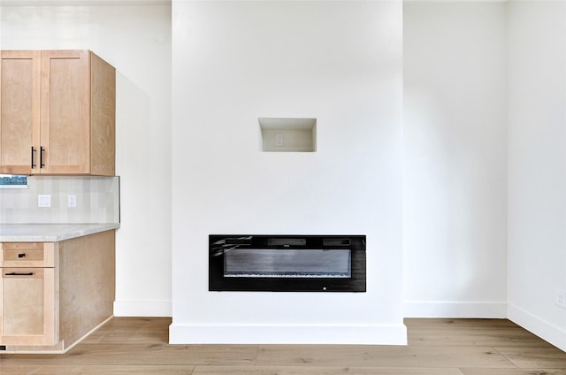 5107 New Orleans St, Houston, TX 77020 - detailed view of a glass covered fireplace, wood finished floors, and baseboards