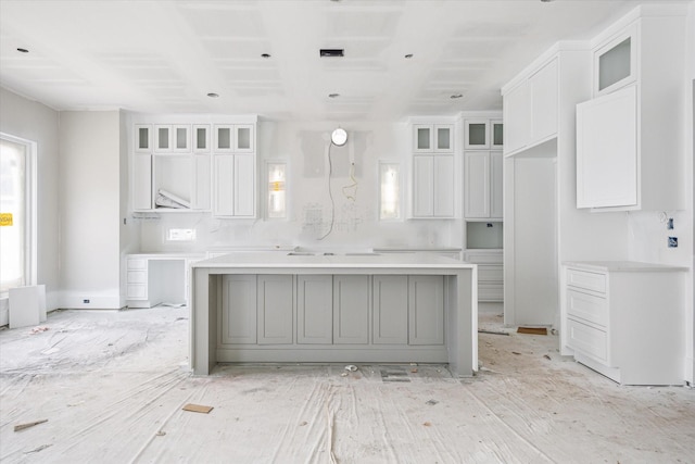 2920 Georgetown St, Houston, TX 77005 - kitchen with white cabinets, a kitchen island, and glass insert cabinets