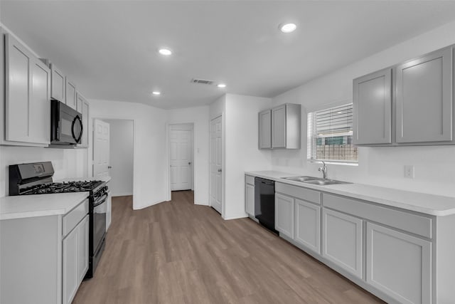 4625 Peralta Heights Way, Porter, TX 77365 - kitchen featuring black appliances, light countertops, recessed lighting, light wood-style floors, and gray cabinetry