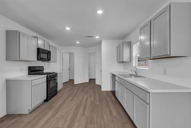 4625 Peralta Heights Way, Porter, TX 77365 - kitchen with black appliances, gray cabinetry, light wood-style floors, light countertops, and recessed lighting