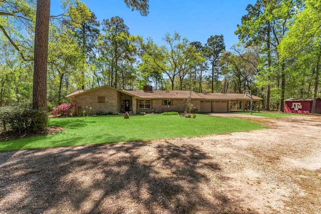 3027 Pine Acres Dr, Conroe, TX 77384 - rear view of house featuring driveway, an attached garage, a lawn, a chimney, and a storage shed
