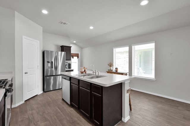 13916 Great Pines Ct, Conroe, TX 77302 - kitchen with appliances with stainless steel finishes, a sink, an island with sink, dark wood-style flooring, and recessed lighting