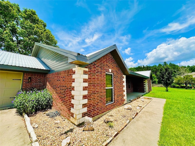 304 Ashwood Bnd, Hudson, TX 75904 - view of property exterior with brick siding, a lawn, an attached garage, and metal roof