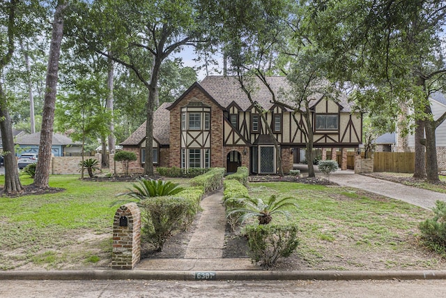 6307 Bayonne Dr, Spring, TX 77389 - tudor home featuring brick siding, driveway, and roof with shingles