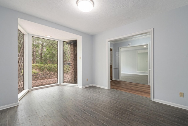 6307 Bayonne Dr, Spring, TX 77389 - empty room featuring dark wood-style flooring, baseboards, and a textured ceiling