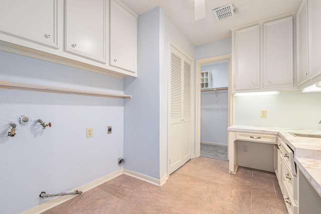 6307 Bayonne Dr, Spring, TX 77389 - laundry area featuring hookup for a gas dryer, electric dryer hookup, baseboards, a sink, and light tile patterned flooring