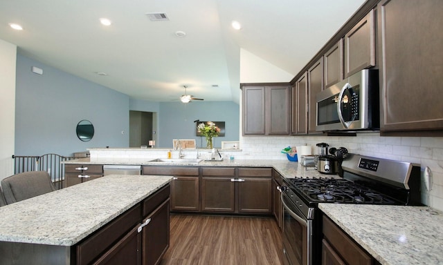 20202 Creekdale Bend Dr, Cypress, TX 77433 - kitchen with appliances with stainless steel finishes, dark brown cabinetry, tasteful backsplash, a sink, and lofted ceiling