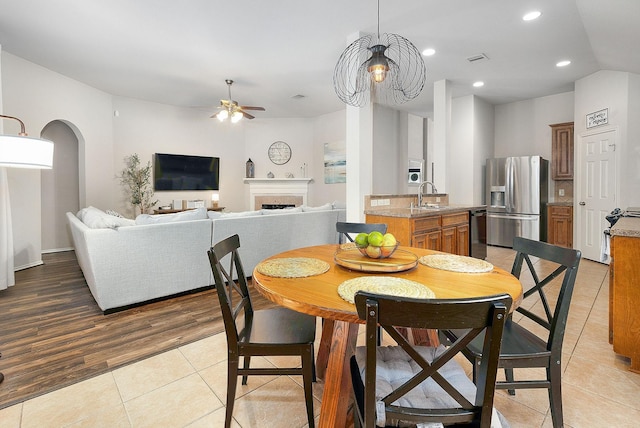 17206 Kobuk Valley Cir, Humble, TX 77346 - dining space featuring ceiling fan, light tile patterned floors, arched walkways, a fireplace, and recessed lighting