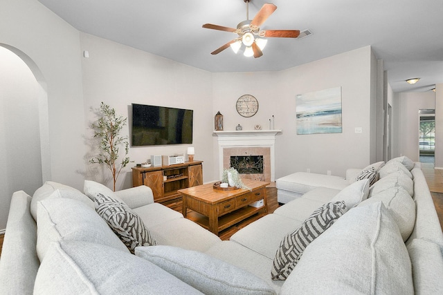 17206 Kobuk Valley Cir, Humble, TX 77346 - living room featuring arched walkways, a ceiling fan, wood finished floors, and a tile fireplace