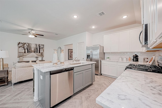 26414 Cooperstown Way, Splendora, TX 77372 - kitchen featuring stainless steel appliances, a ceiling fan, light stone counters, a sink, and white cabinetry