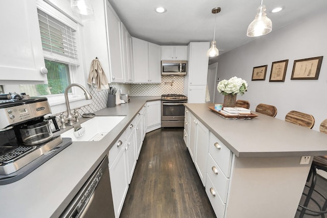 1038 Lawrence St, Houston, TX 77008 - kitchen with appliances with stainless steel finishes, a breakfast bar area, decorative backsplash, dark wood-style flooring, and white cabinets