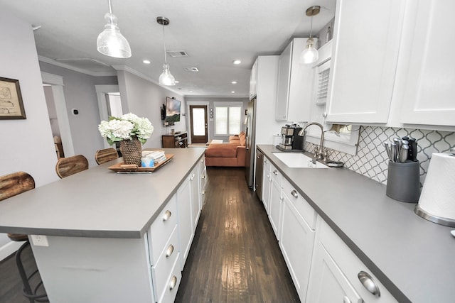 1038 Lawrence St, Houston, TX 77008 - kitchen with a kitchen bar, dark wood-type flooring, open floor plan, white cabinetry, and crown molding