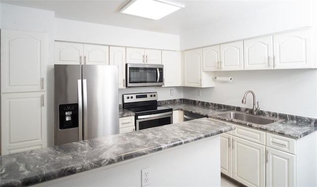 16800 Sugar Pine Dr Unit F44, Houston, TX 77090 - kitchen featuring appliances with stainless steel finishes, a sink, white cabinets, and dark stone countertops
