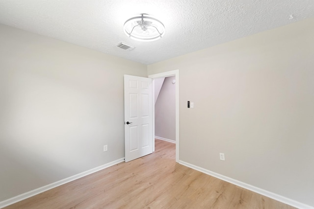 11114 Daybreak Ln, Cypress, TX 77429 - empty room with light wood-type flooring, baseboards, and a textured ceiling