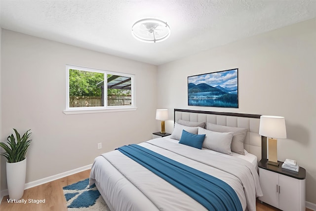 11114 Daybreak Ln, Cypress, TX 77429 - bedroom with light wood-style flooring, baseboards, and a textured ceiling