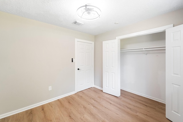 11114 Daybreak Ln, Cypress, TX 77429 - unfurnished bedroom featuring wood finished floors, baseboards, a closet, and a textured ceiling