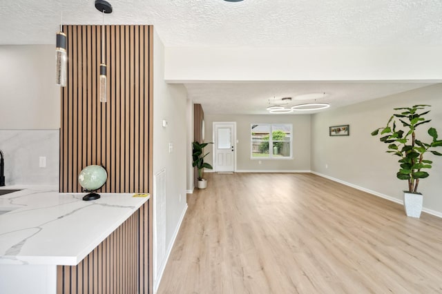 11114 Daybreak Ln, Cypress, TX 77429 - interior space with light wood-type flooring, a textured ceiling, baseboards, and a chandelier