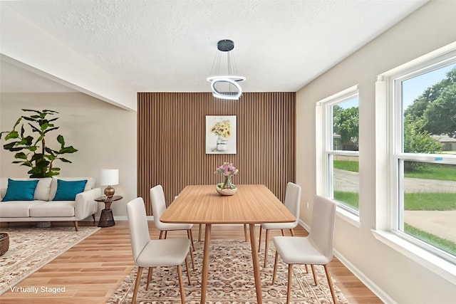 11114 Daybreak Ln, Cypress, TX 77429 - dining space featuring light wood finished floors, healthy amount of natural light, baseboards, an accent wall, and a textured ceiling