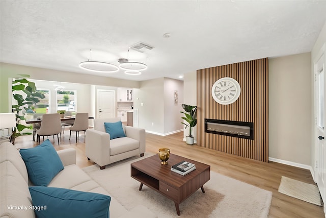 11114 Daybreak Ln, Cypress, TX 77429 - living room with baseboards, light wood-type flooring, and a glass covered fireplace