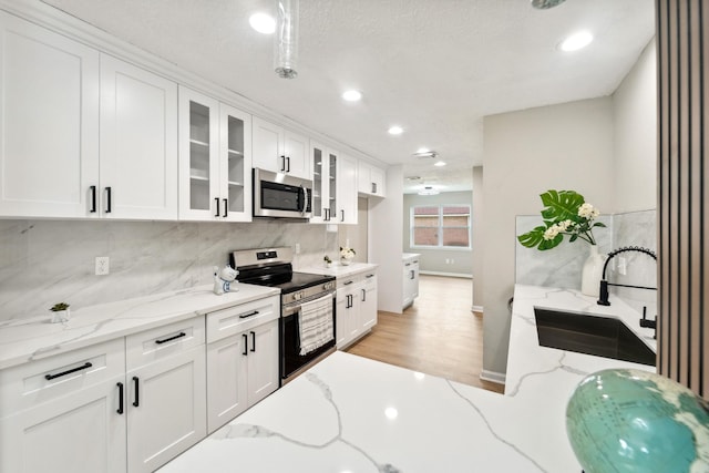 11114 Daybreak Ln, Cypress, TX 77429 - kitchen with appliances with stainless steel finishes, a sink, glass insert cabinets, white cabinets, and backsplash