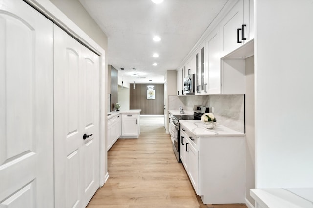 11114 Daybreak Ln, Cypress, TX 77429 - kitchen featuring stainless steel appliances, white cabinetry, recessed lighting, light wood-style floors, and glass insert cabinets