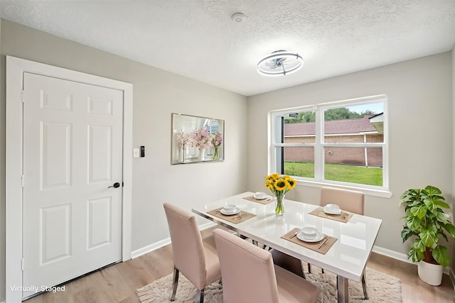 11114 Daybreak Ln, Cypress, TX 77429 - dining space featuring light wood finished floors, baseboards, and a textured ceiling