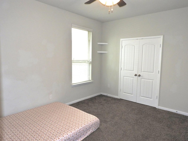 2705 Osprey Ln, Pearland, TX 77581 - unfurnished bedroom with dark carpet, a closet, baseboards, and ceiling fan