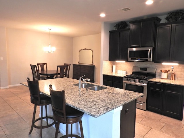 2705 Osprey Ln, Pearland, TX 77581 - kitchen featuring appliances with stainless steel finishes, a sink, dark cabinetry, decorative backsplash, and recessed lighting