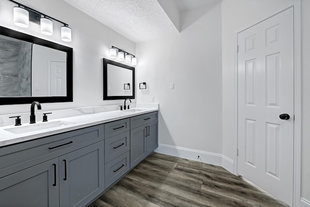 1826 Cheyenne River Cir, Sugar Land, TX 77478 - bathroom with double vanity, wood finished floors, baseboards, and a textured ceiling