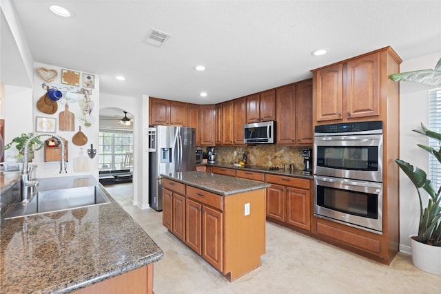 10711 Indian Trails Dr, Tomball, TX 77375 - kitchen with a sink, stainless steel appliances, dark stone countertops, a kitchen island, and backsplash